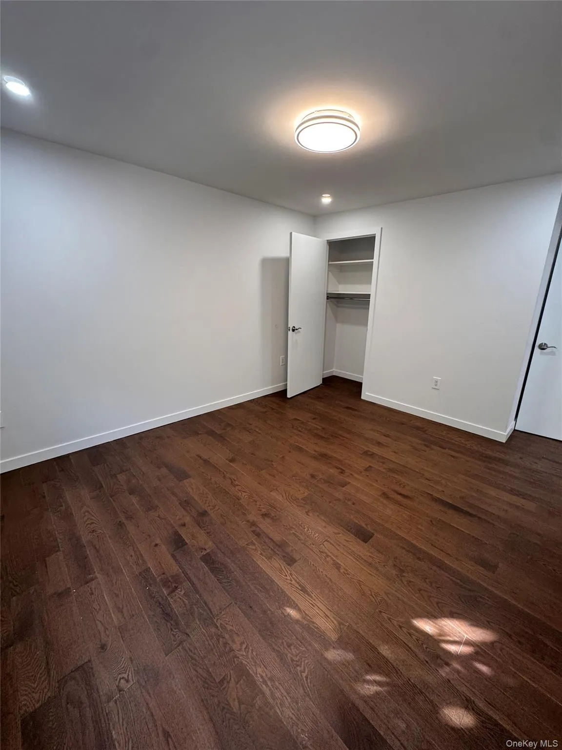 Unfurnished bedroom featuring dark wood-style floors and a closet Unfurnished bedroom featuring dark wood-style floors and a closet
