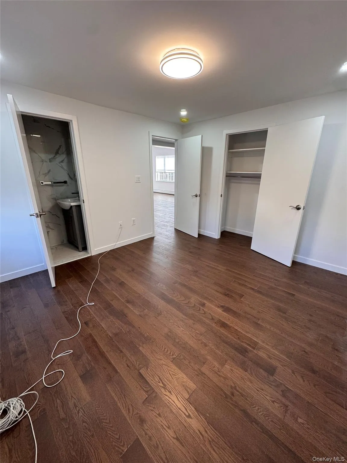 Unfurnished bedroom featuring a closet, dark wood-style floors, and connected bathroom Unfurnished bedroom featuring a closet, dark wood-style floors, and connected bathroom