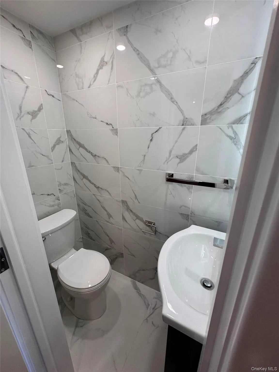 Bathroom with vanity, tile walls, and marble finish floors Bathroom with vanity, tile walls, and marble finish floors