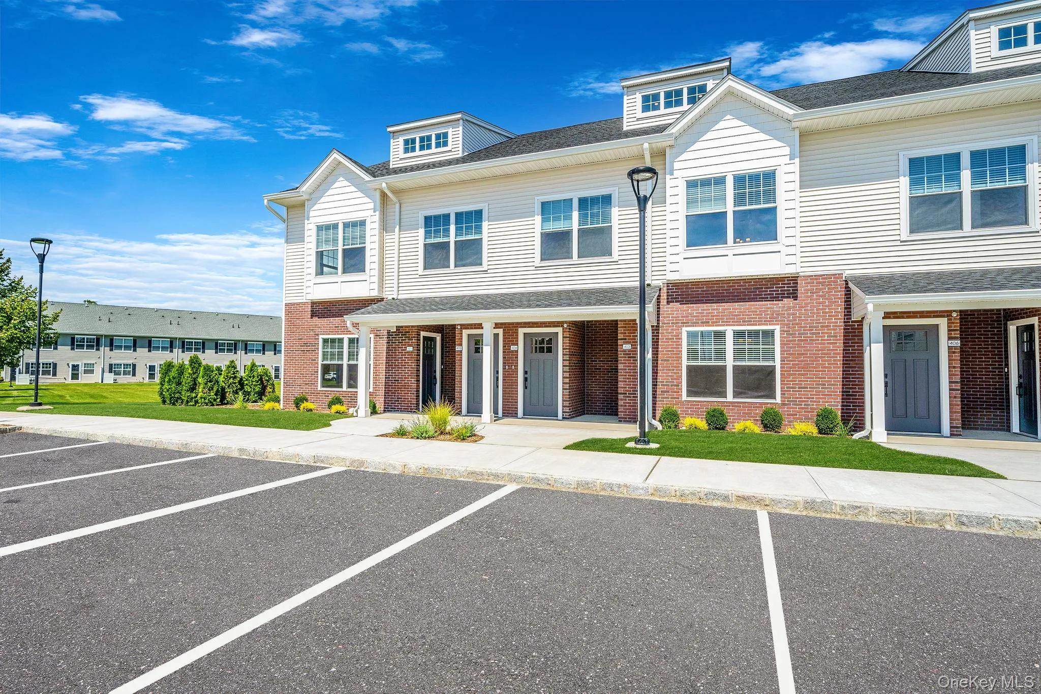 View of front of home with uncovered parking, brick siding, and a front lawn View of front of home with uncovered parking, brick siding, and a front lawn