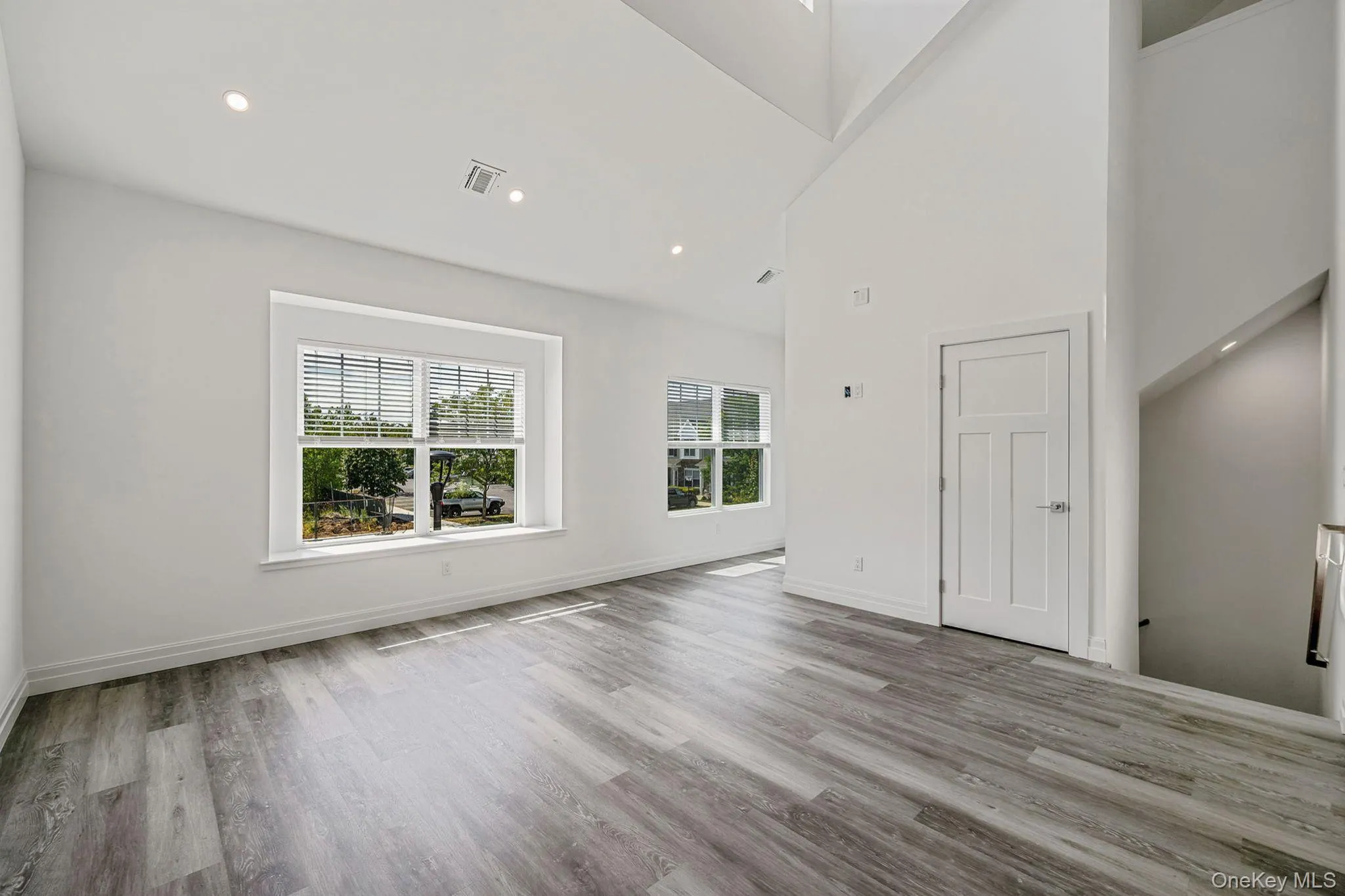 Unfurnished living room featuring recessed lighting, light wood-type flooring, and high vaulted ceiling Unfurnished living room featuring recessed lighting, light wood-type flooring, and high vaulted ceiling