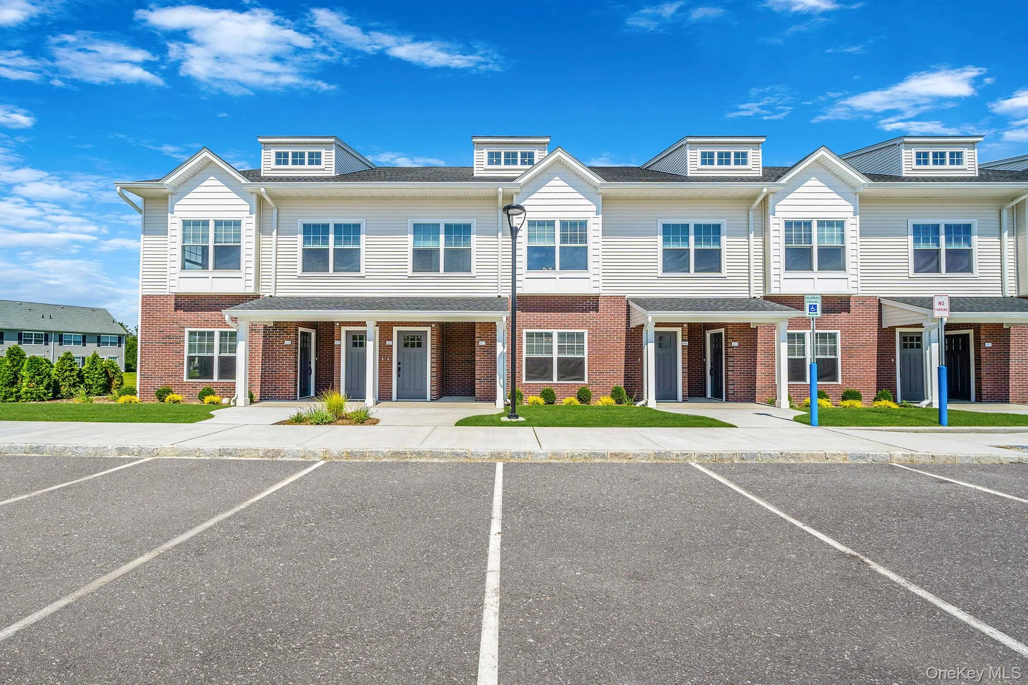 Traditional home with uncovered parking and brick siding Traditional home with uncovered parking and brick siding