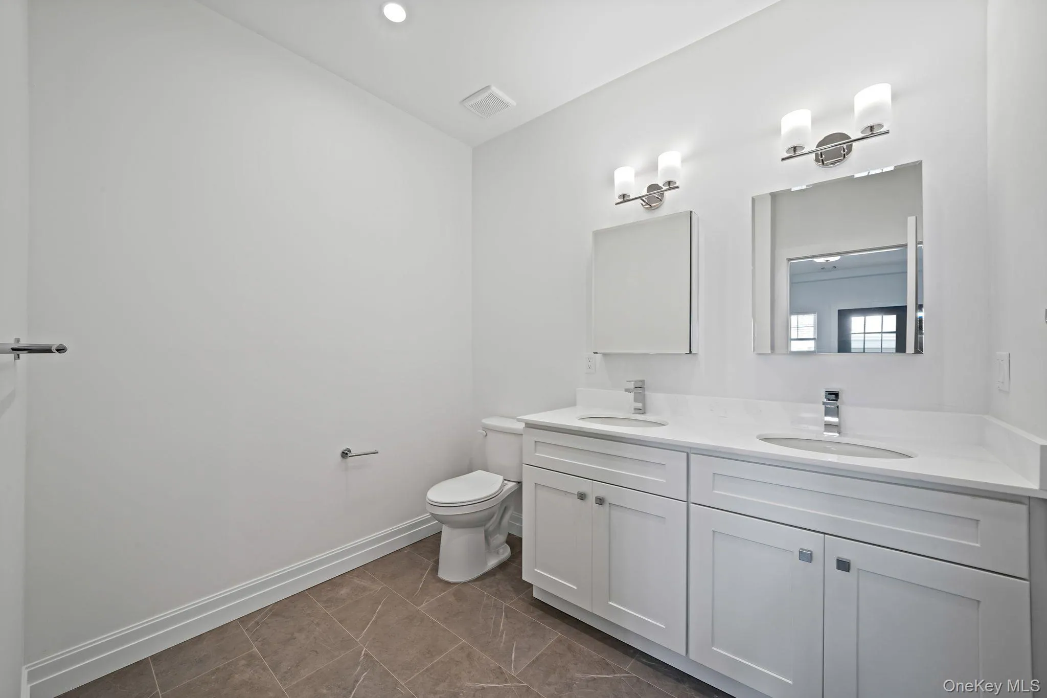 Full bathroom featuring double vanity, dark tile patterned flooring, and recessed lighting Full bathroom featuring double vanity, dark tile patterned flooring, and recessed lighting