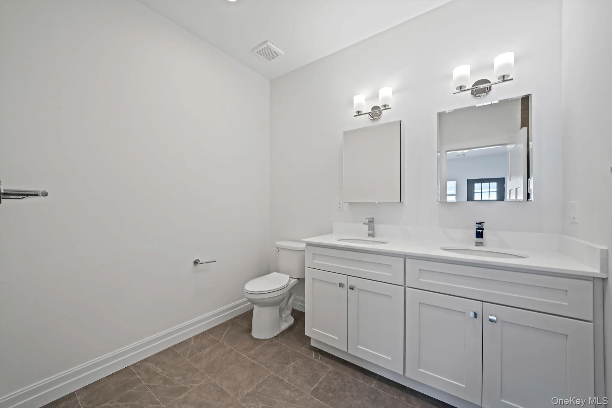 Full bath featuring double vanity and dark tile patterned flooring Full bath featuring double vanity and dark tile patterned flooring