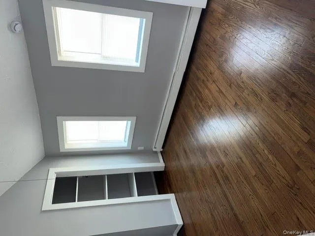Unfurnished bedroom with a baseboard heating unit, a textured ceiling, dark wood-style floors, lofted ceiling, and a closet Unfurnished bedroom with a baseboard heating unit, a textured ceiling, dark wood-style floors, lofted ceiling, and a closet