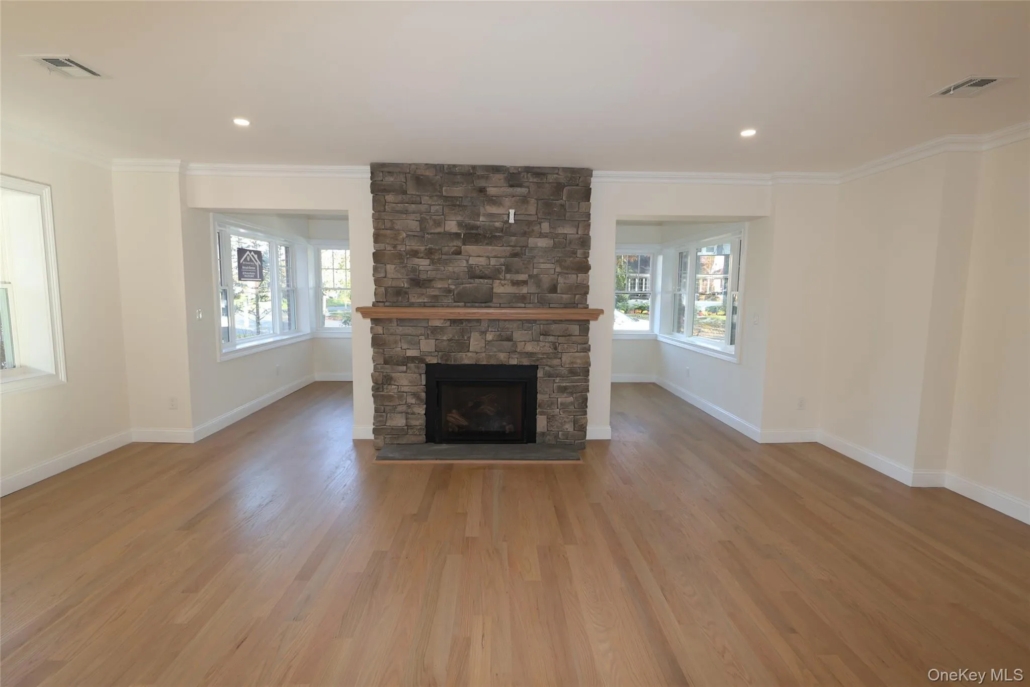 Unfurnished living room with a fireplace, crown molding, light wood-style floors, and recessed lighting Unfurnished living room with a fireplace, crown molding, light wood-style floors, and recessed lighting