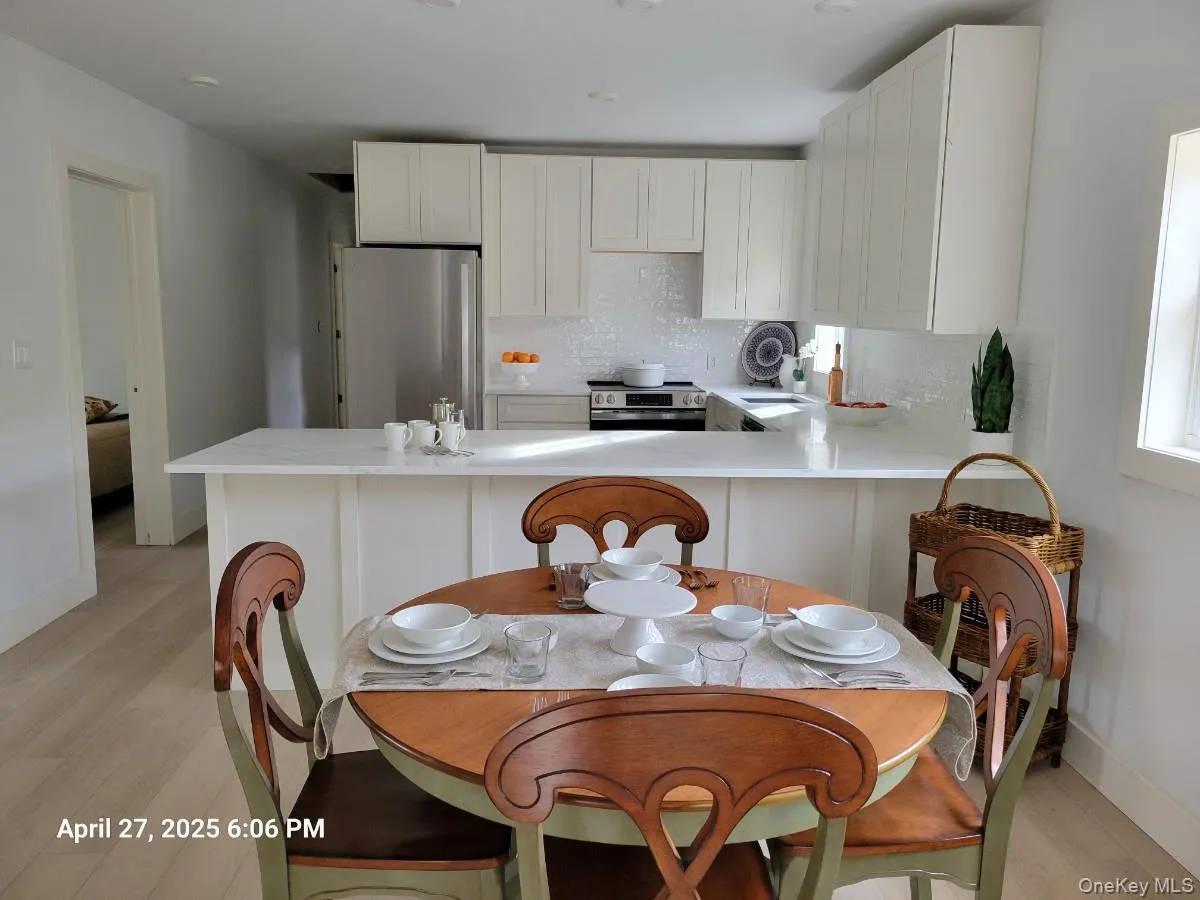 Kitchen with decorative backsplash, appliances with stainless steel finishes, light wood finished floors, and white cabinets Kitchen with decorative backsplash, appliances with stainless steel finishes, light wood finished floors, and white cabinets
