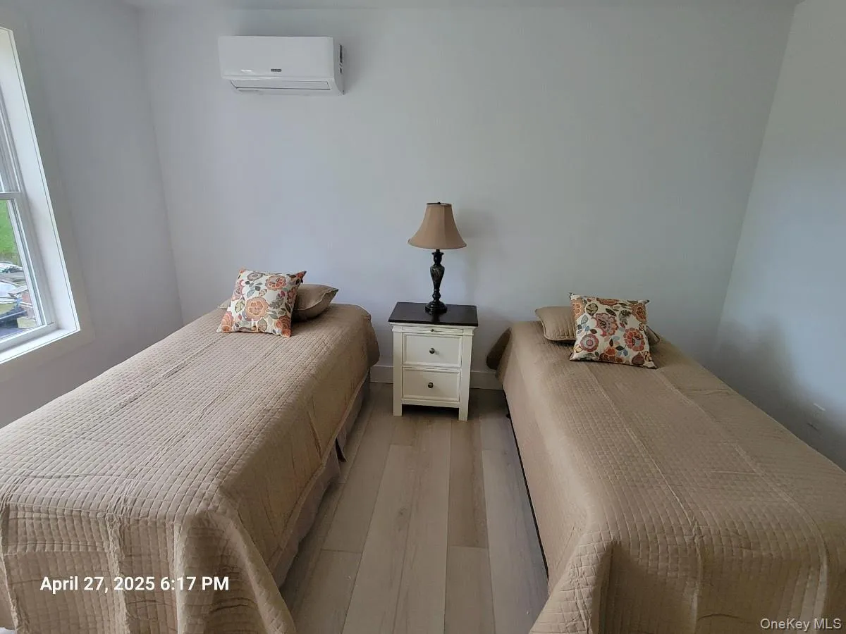 Bedroom with wood finished floors and a wall mounted AC Bedroom with wood finished floors and a wall mounted AC