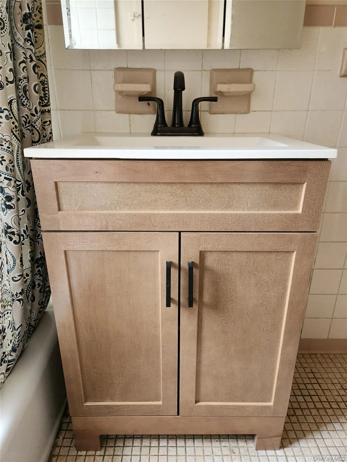 Bathroom view of vanity, shower / bath combination with curtain, and backsplash Bathroom view of vanity, shower / bath combination with curtain, and backsplash