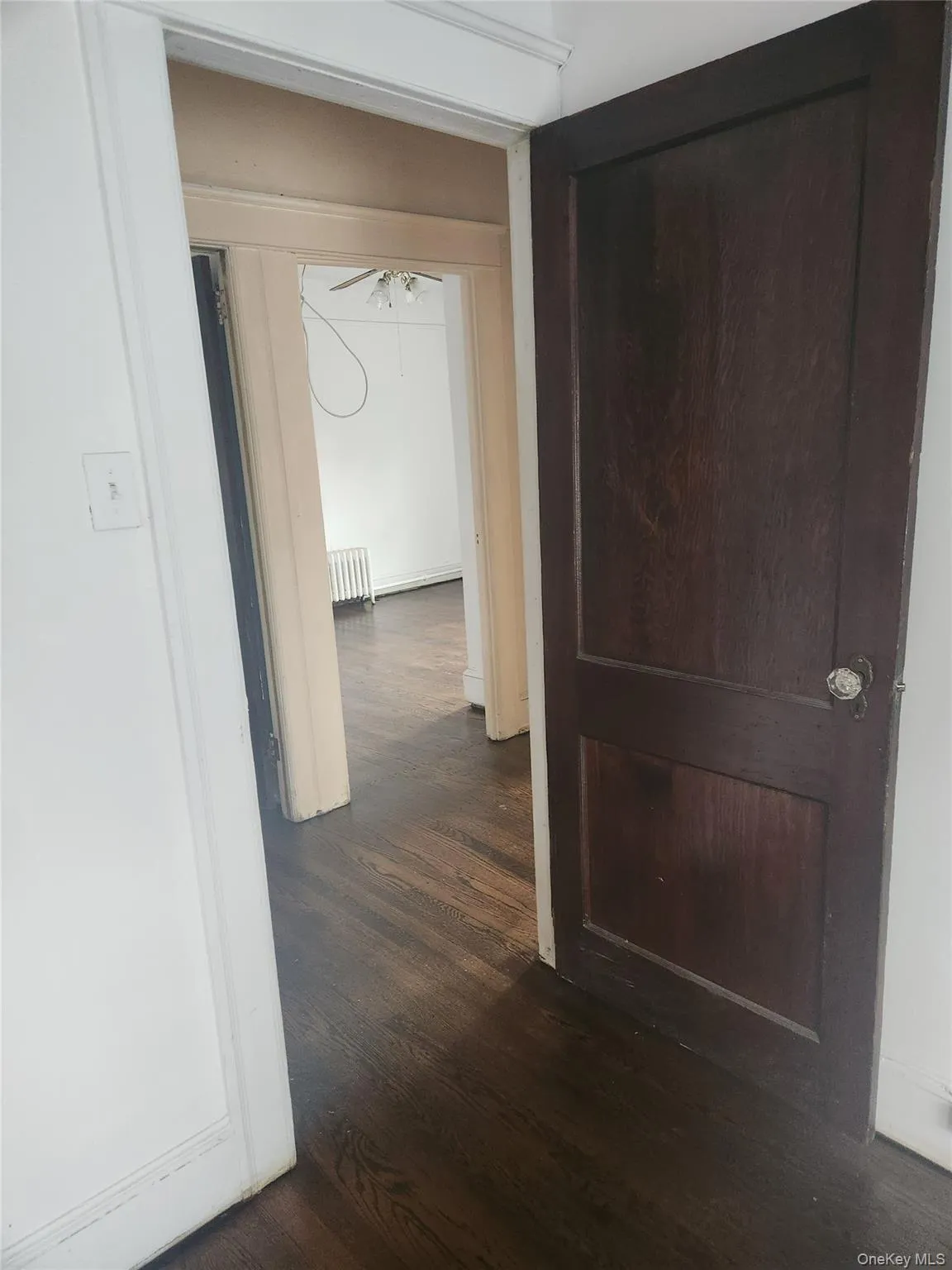 Corridor with dark wood finished floors and radiator Corridor with dark wood finished floors and radiator