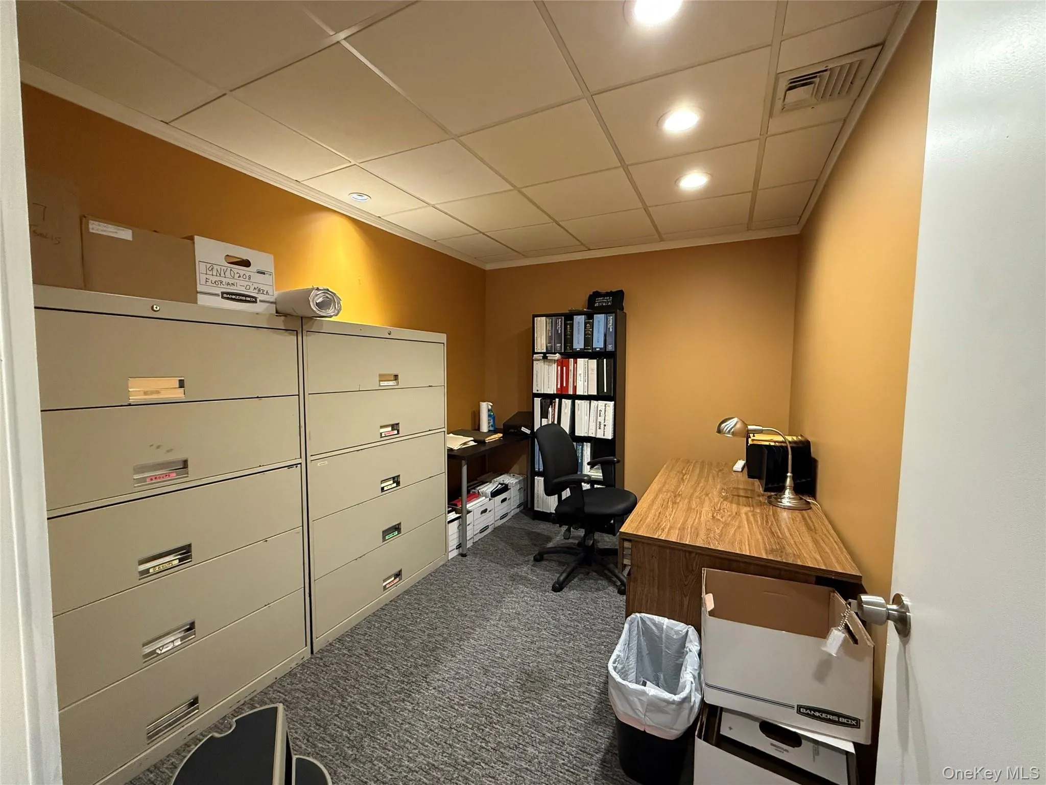 Office space featuring dark colored carpet, a paneled ceiling, and recessed lighting Office space featuring dark colored carpet, a paneled ceiling, and recessed lighting