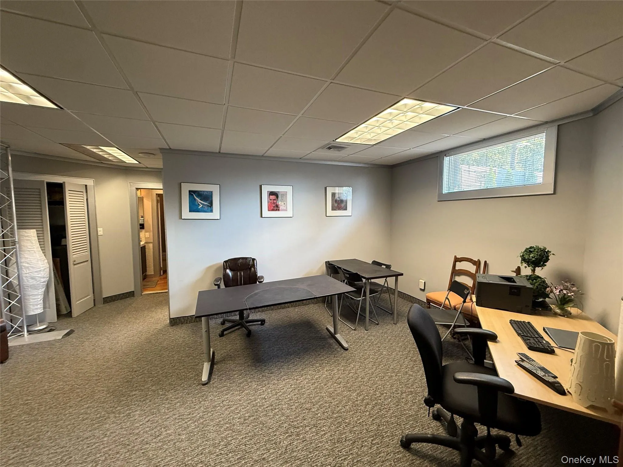 Carpeted office with a drop ceiling and baseboards Carpeted office with a drop ceiling and baseboards