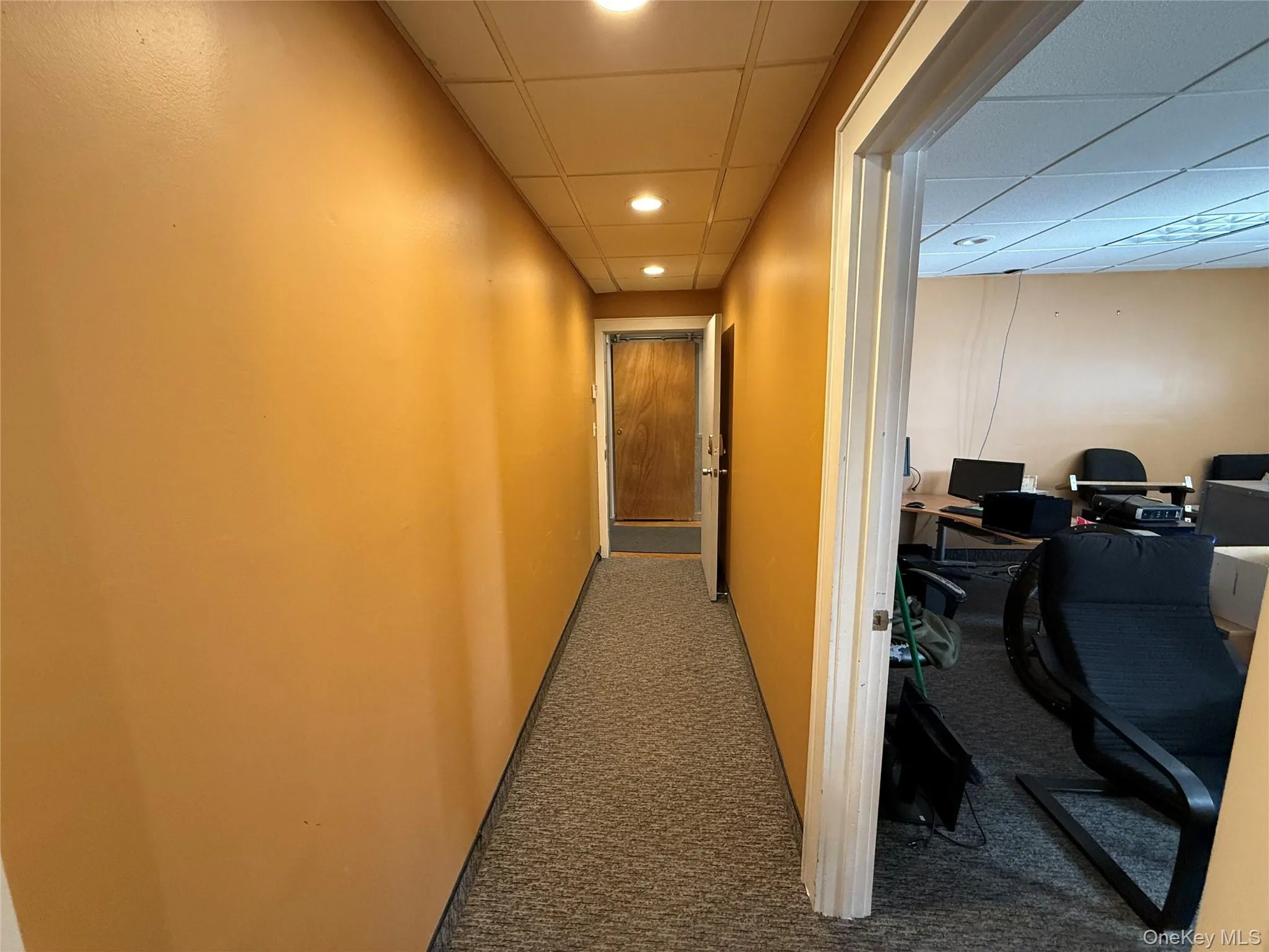 Hallway featuring a drop ceiling, an office area, carpet floors, and recessed lighting Hallway featuring a drop ceiling, an office area, carpet floors, and recessed lighting