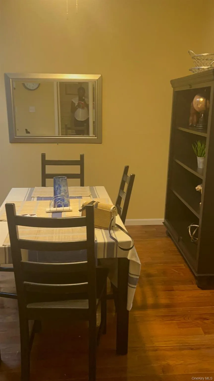 Dining space with dark wood-type flooring and baseboards Dining space with dark wood-type flooring and baseboards