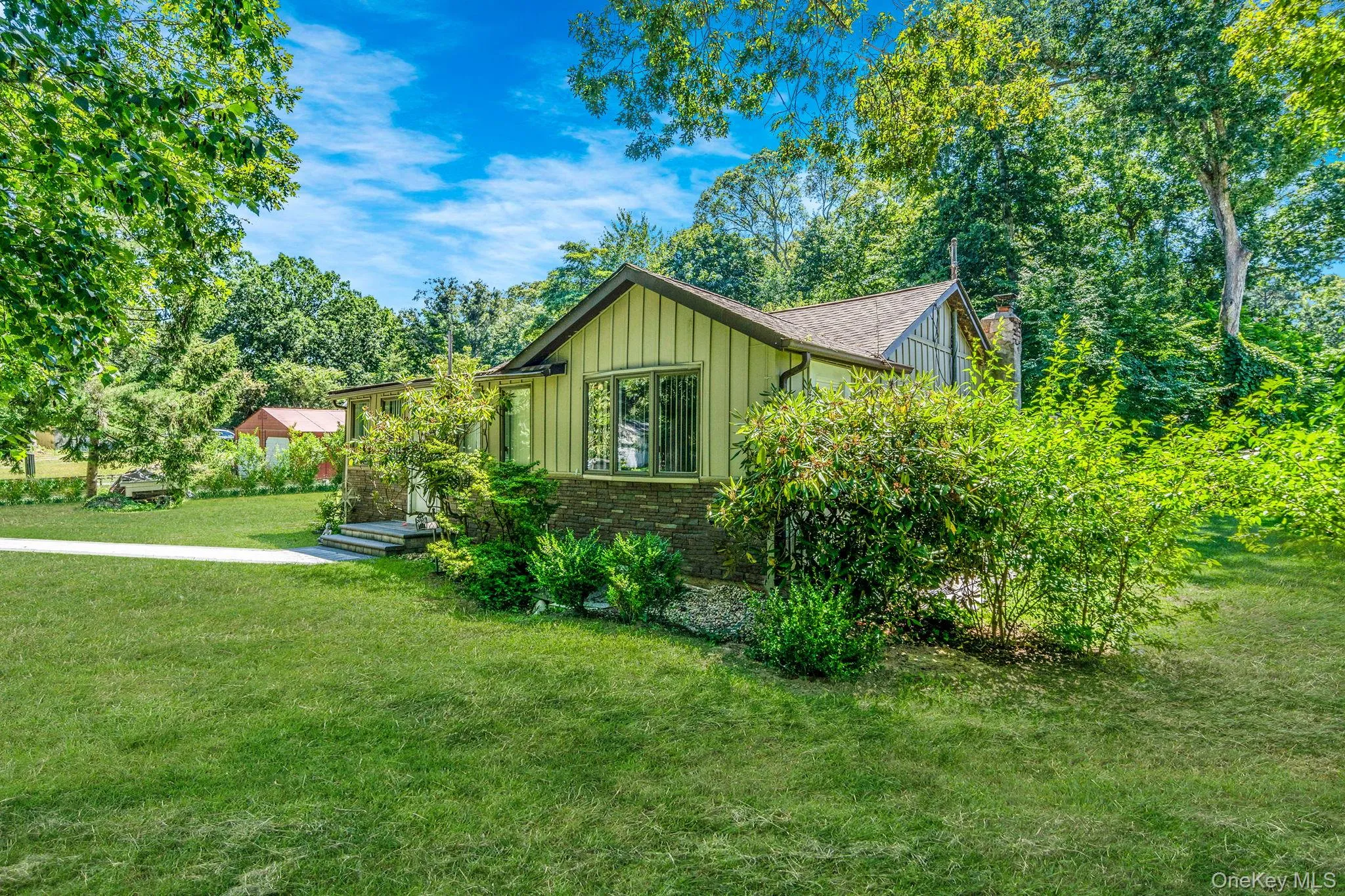 View of home's exterior with board and batten siding, a yard, and brick siding View of home's exterior with board and batten siding, a yard, and brick siding