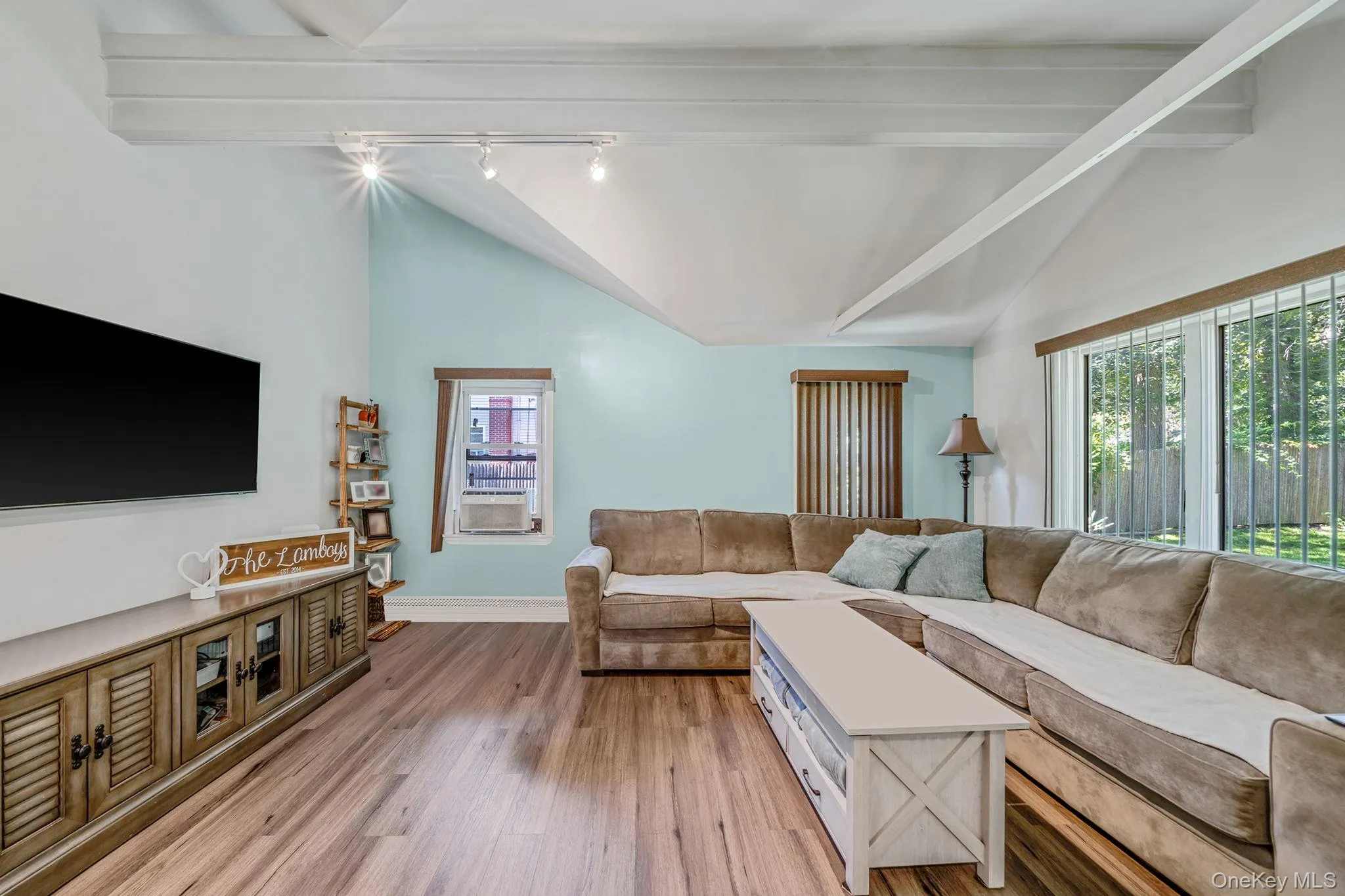 Living area featuring light wood-style flooring and rail lighting Living area featuring light wood-style flooring and rail lighting