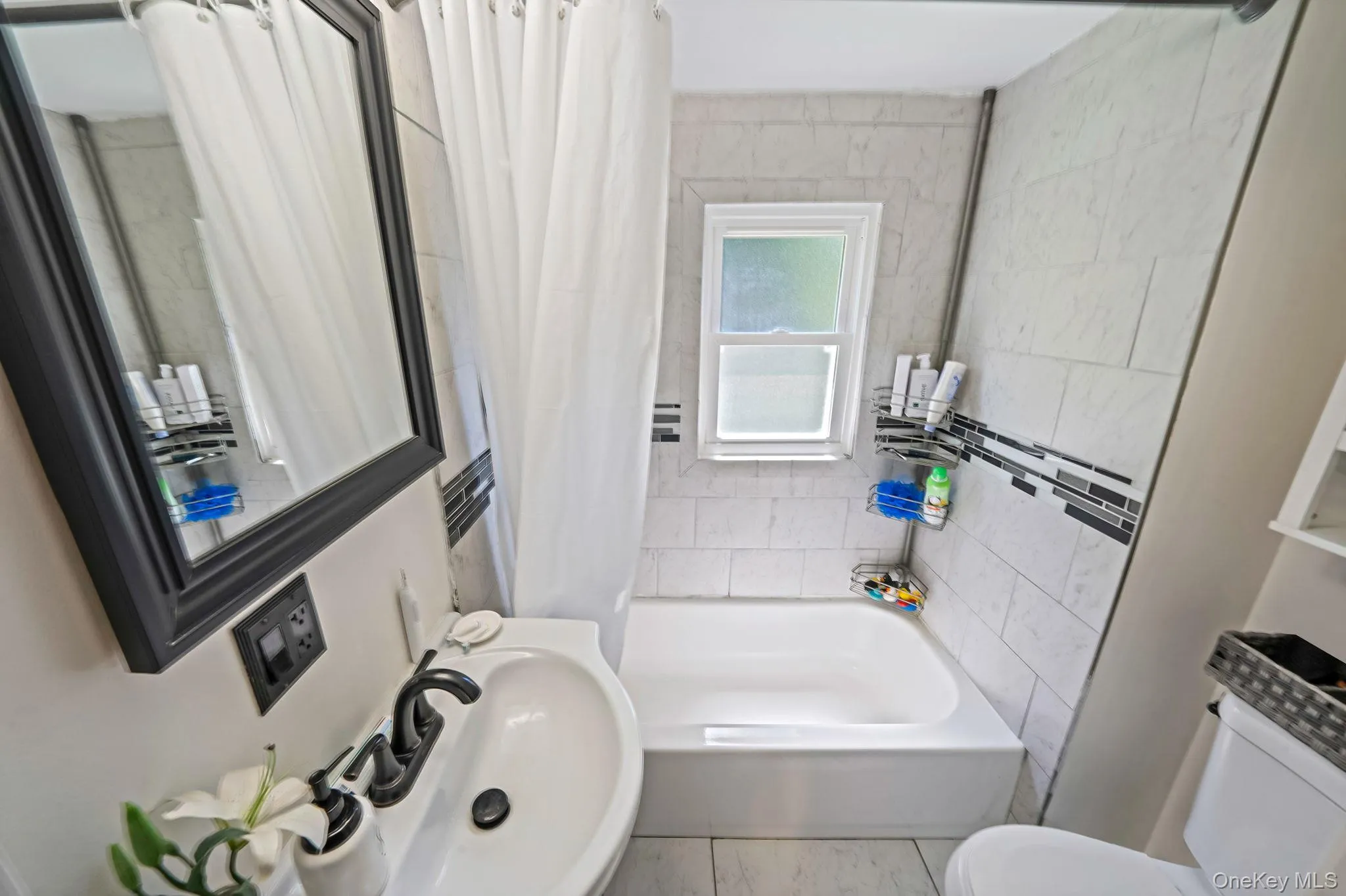 Full bathroom featuring shower / bath combo with shower curtain and tile walls Full bathroom featuring shower / bath combo with shower curtain and tile walls