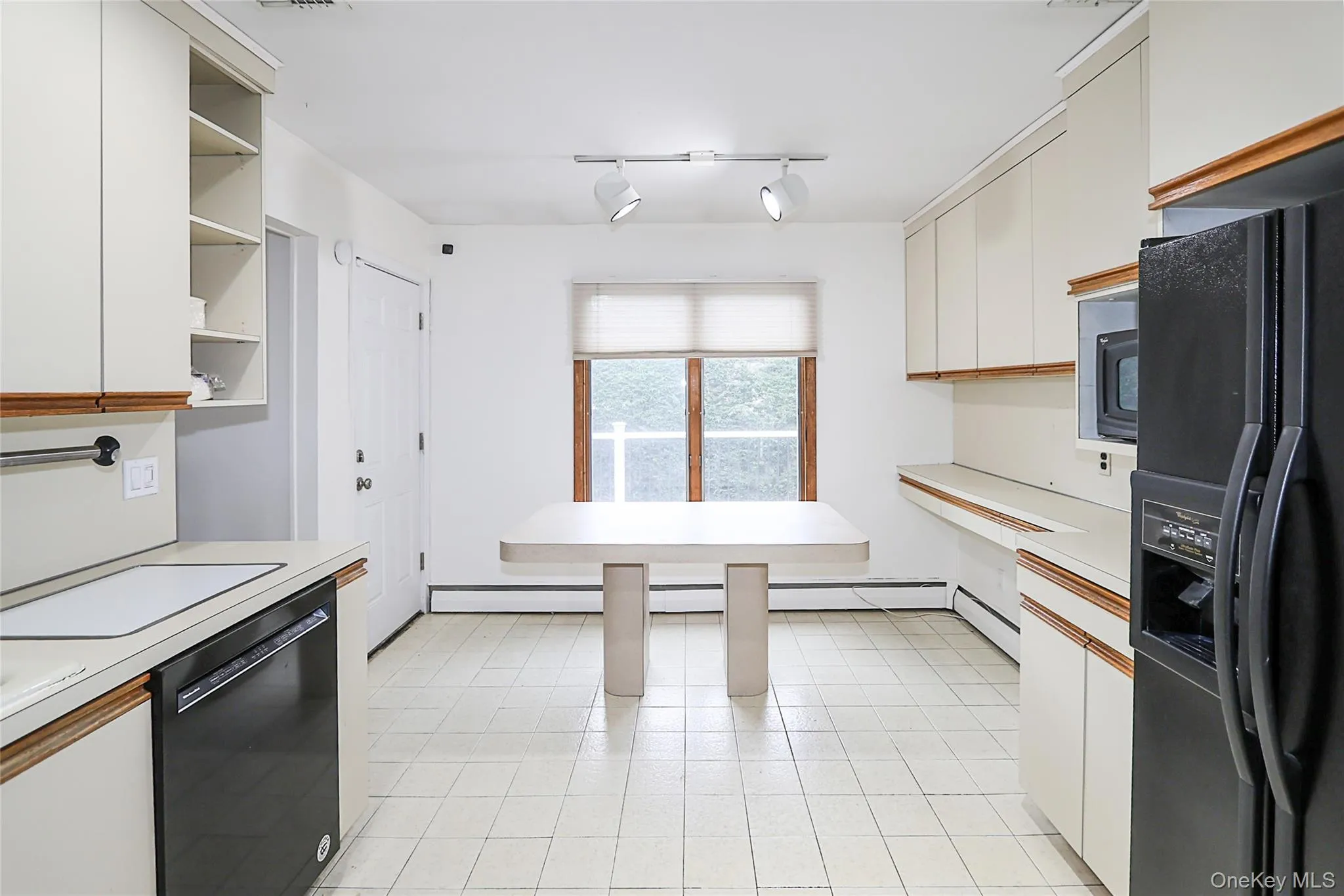 Kitchen featuring light countertops, black appliances, white cabinetry, open shelves, and rail lighting Kitchen featuring light countertops, black appliances, white cabinetry, open shelves, and rail lighting