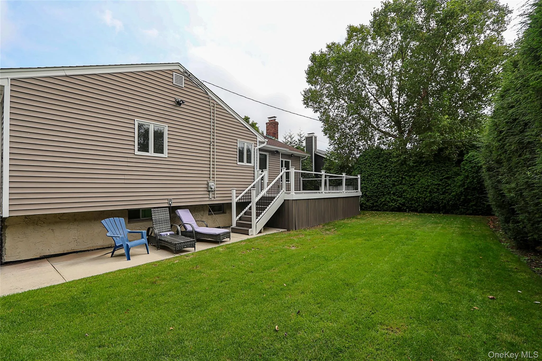 Back of property featuring a lawn, stairs, a patio area, and a deck Back of property featuring a lawn, stairs, a patio area, and a deck