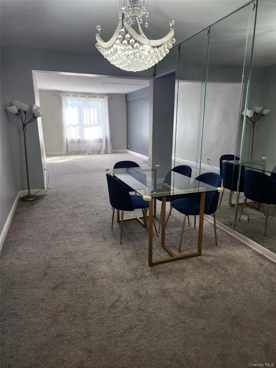 Carpeted dining room featuring a chandelier and baseboards Carpeted dining room featuring a chandelier and baseboards