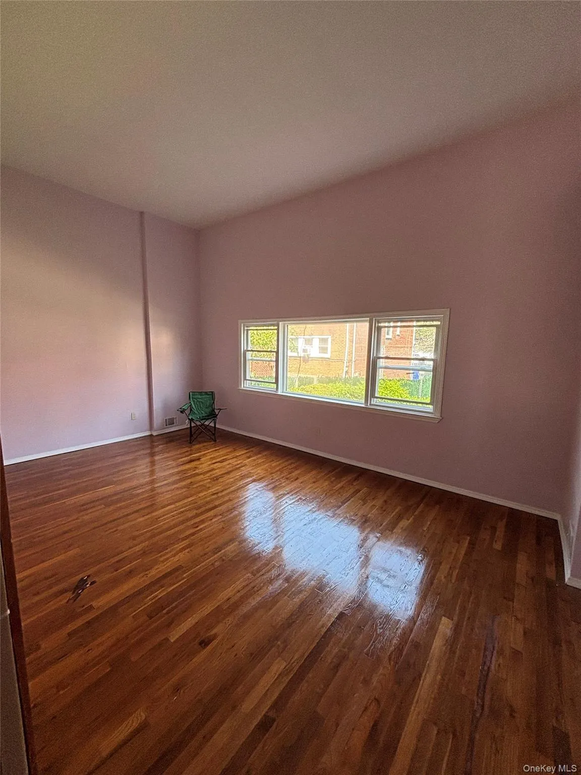 Unfurnished room with dark wood-type flooring and baseboards Unfurnished room with dark wood-type flooring and baseboards