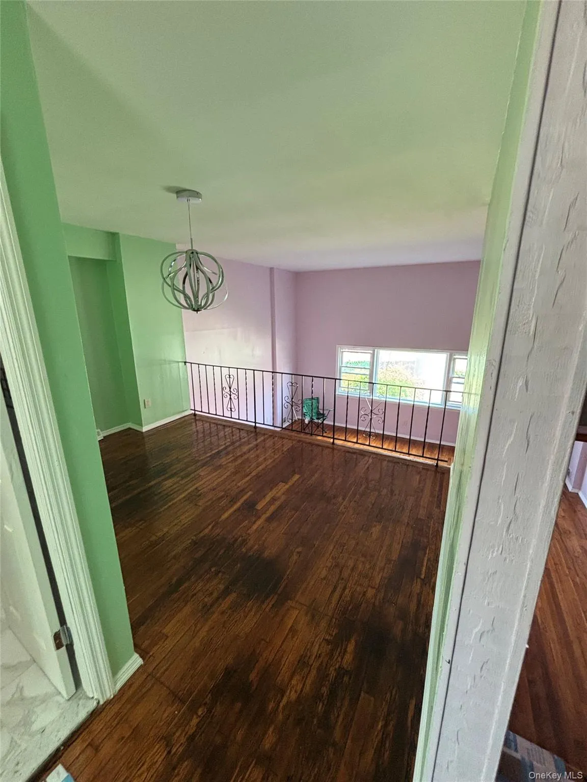 Unfurnished living room featuring dark wood-type flooring and a chandelier Unfurnished living room featuring dark wood-type flooring and a chandelier