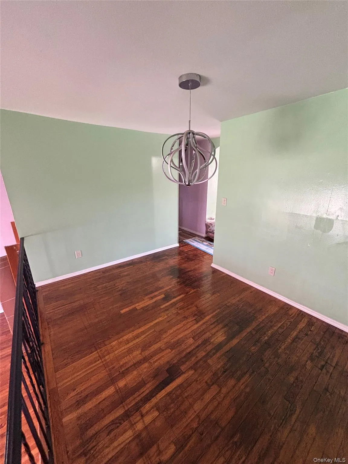 Unfurnished dining area featuring a chandelier and dark wood-type flooring Unfurnished dining area featuring a chandelier and dark wood-type flooring