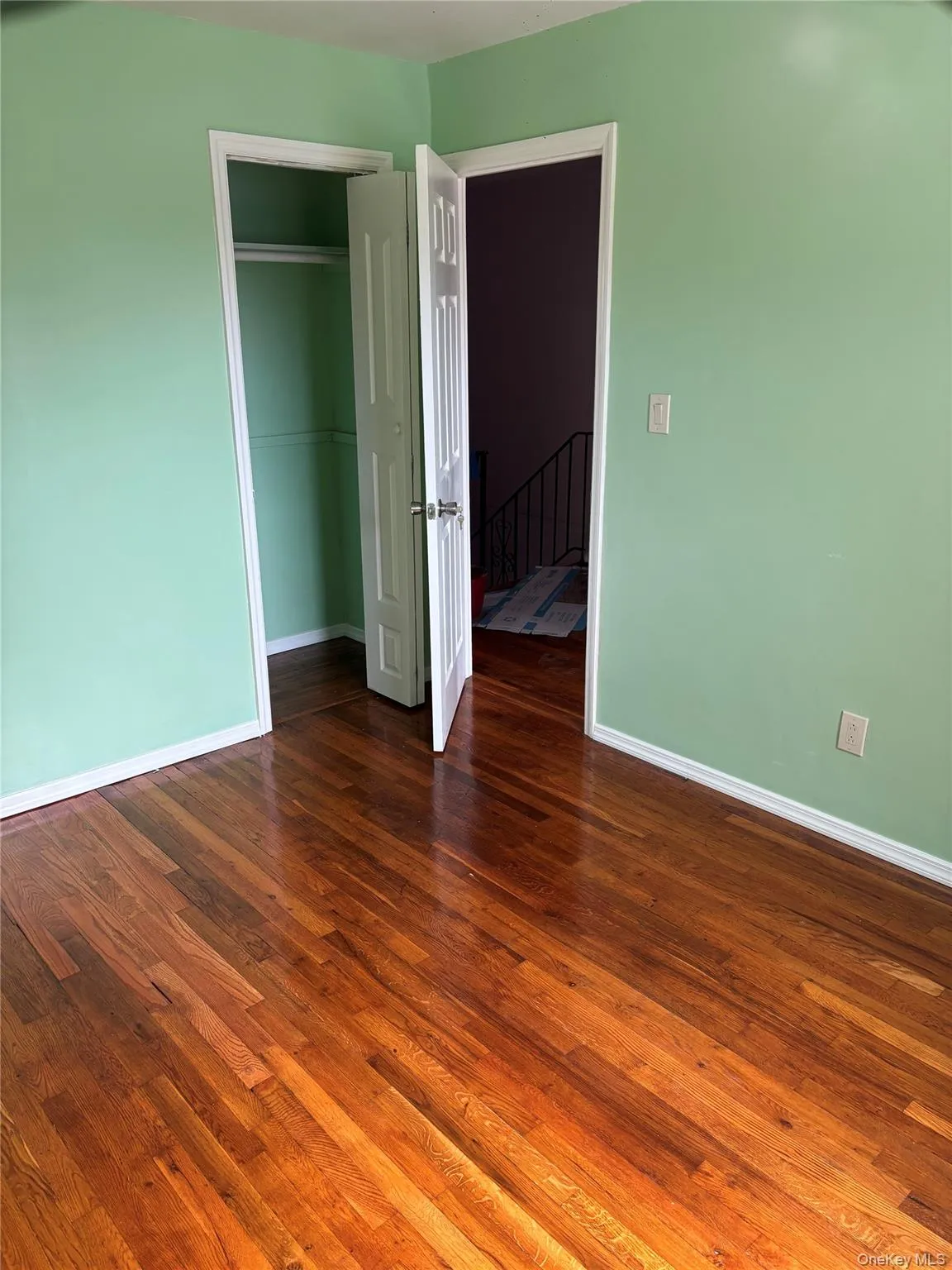 Unfurnished bedroom featuring dark wood-type flooring and a closet Unfurnished bedroom featuring dark wood-type flooring and a closet