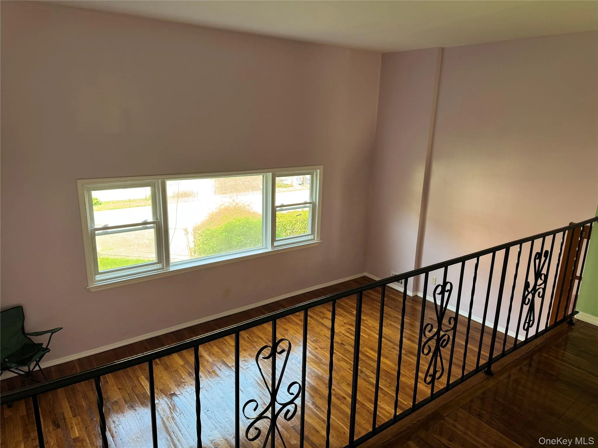 Stairs featuring hardwood / wood-style flooring and healthy amount of natural light Stairs featuring hardwood / wood-style flooring and healthy amount of natural light