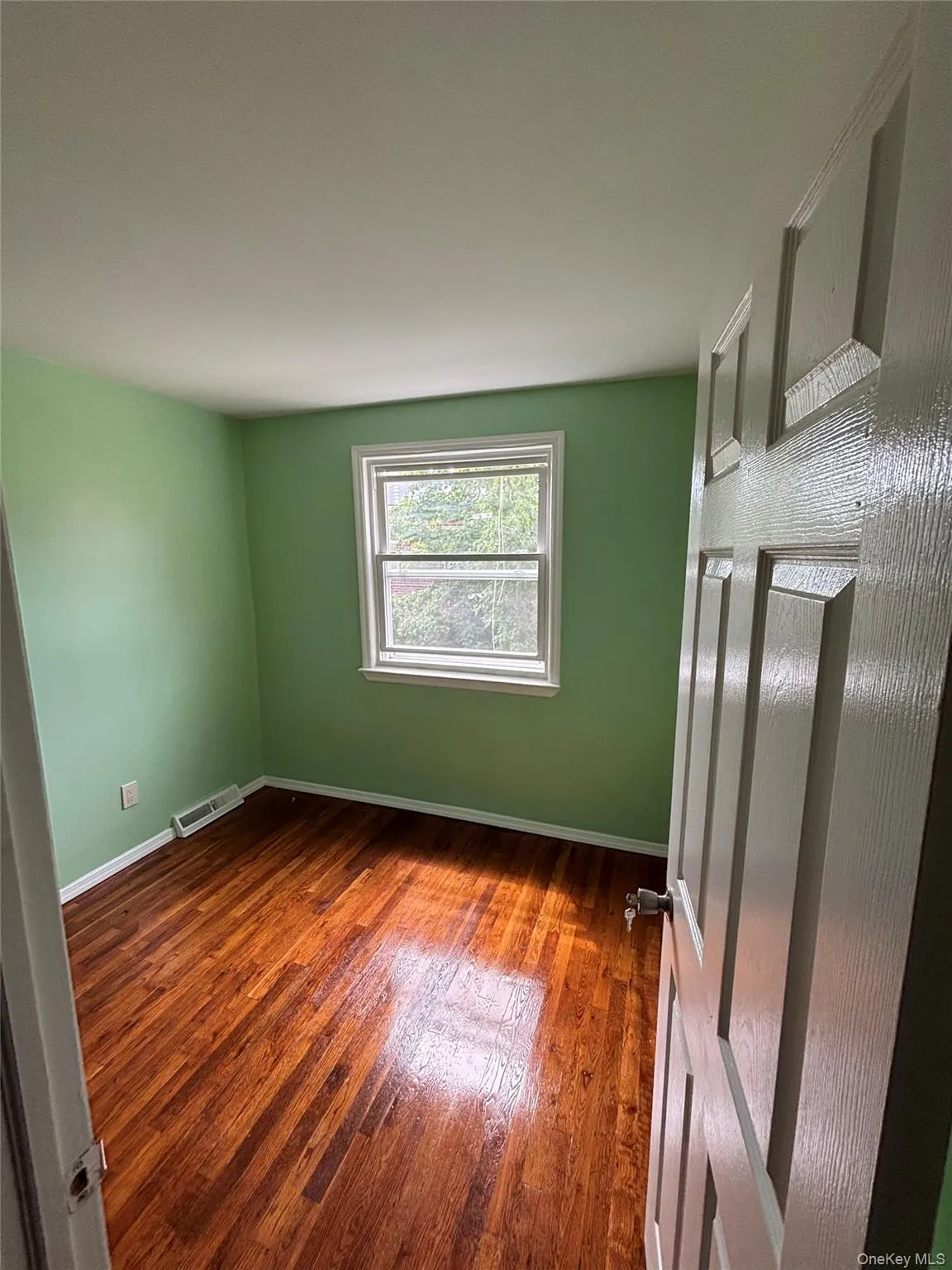 Spare room featuring baseboards and wood finished floors Spare room featuring baseboards and wood finished floors