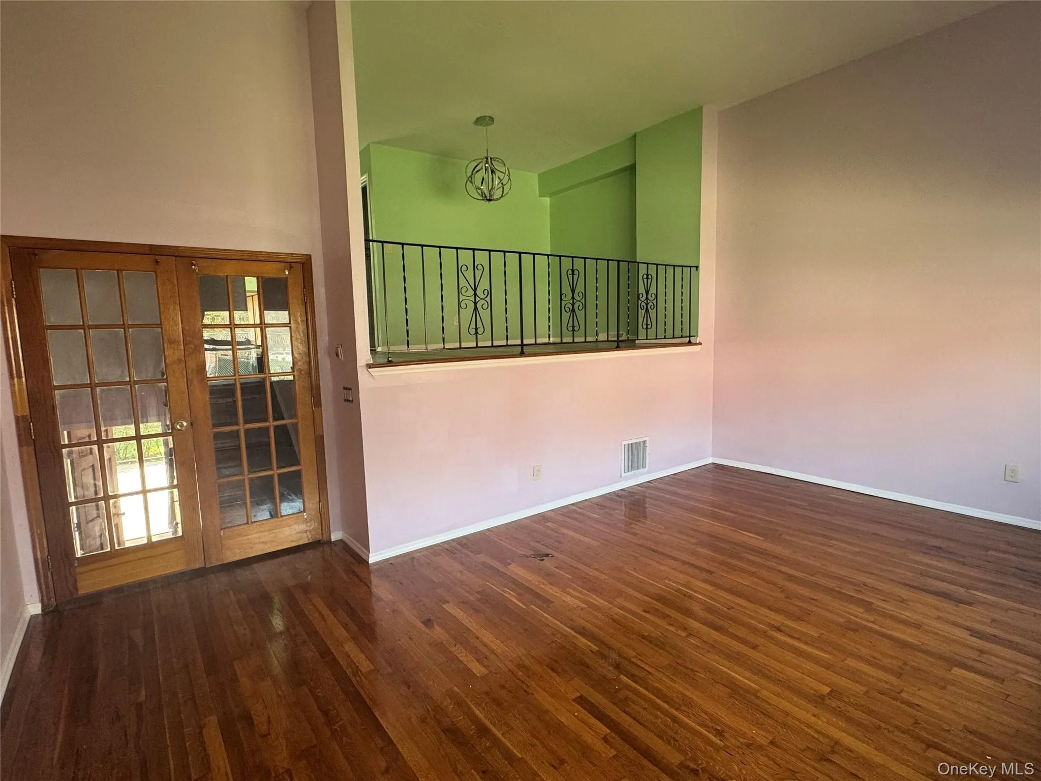 Empty room featuring dark wood finished floors and french doors Empty room featuring dark wood finished floors and french doors