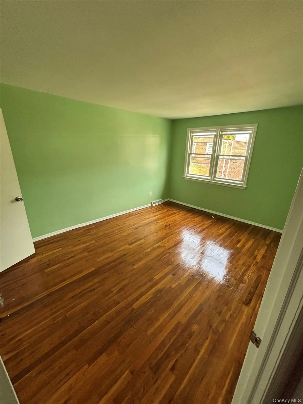 Unfurnished room with dark wood-style floors and baseboards Unfurnished room with dark wood-style floors and baseboards
