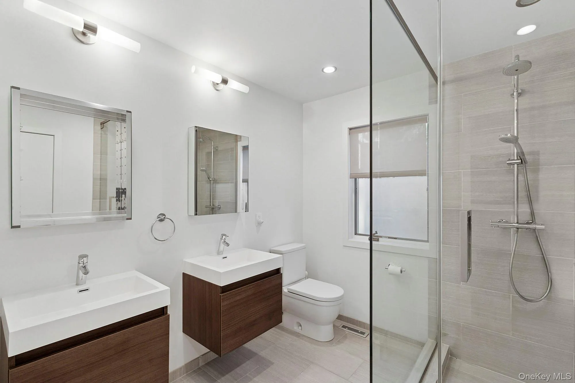 Bathroom featuring two vanities, a stall shower, and recessed lighting Bathroom featuring two vanities, a stall shower, and recessed lighting