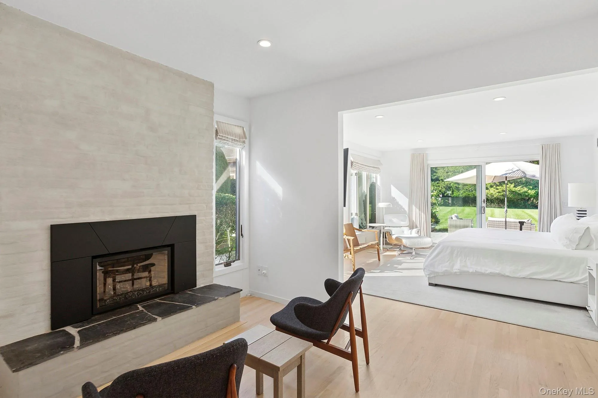 Bedroom featuring wood finished floors, a fireplace, and recessed lighting Bedroom featuring wood finished floors, a fireplace, and recessed lighting