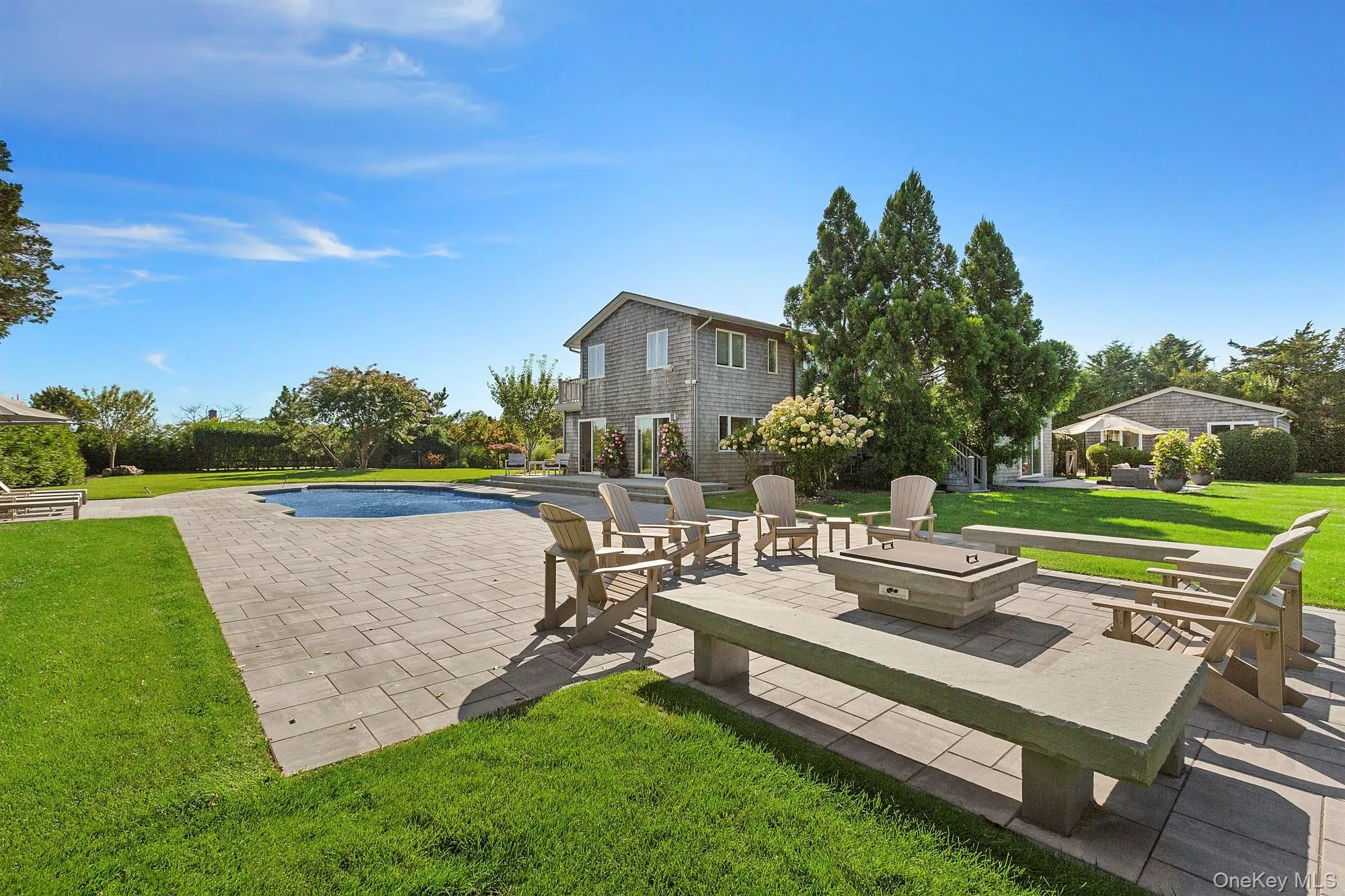 Outdoor pool with a lawn and a patio area Outdoor pool with a lawn and a patio area