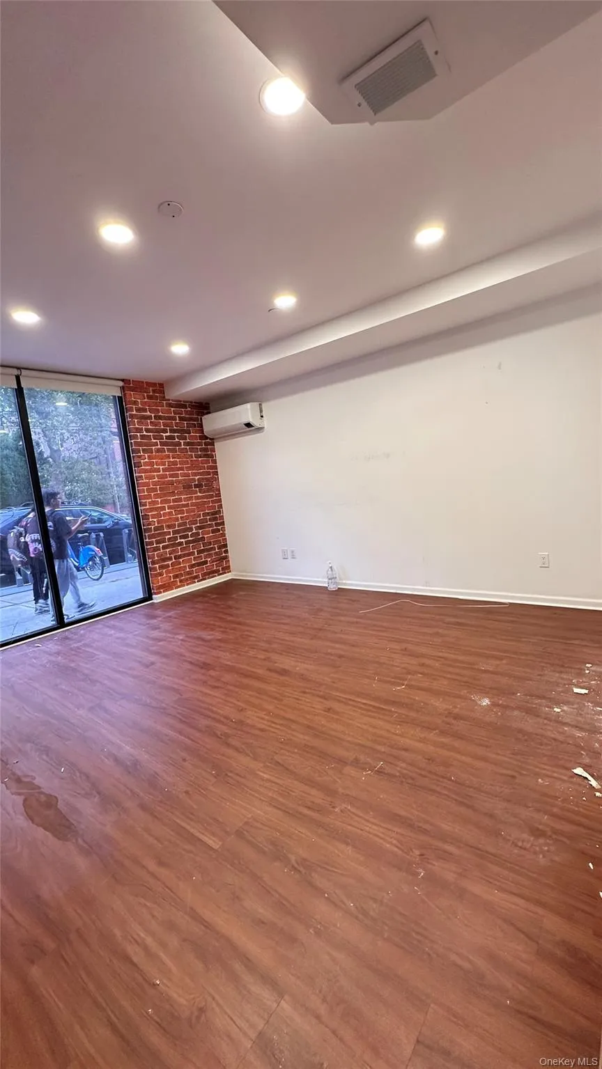 Unfurnished living room featuring wood finished floors and recessed lighting Unfurnished living room featuring wood finished floors and recessed lighting
