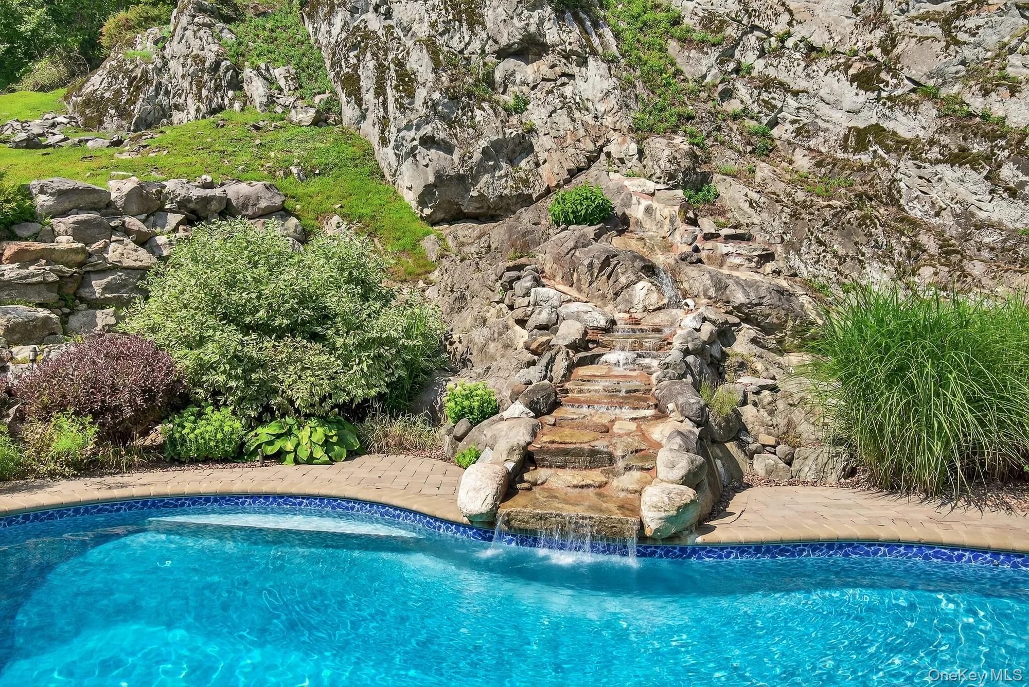 View of outdoor pool with waterfall set into the rock ledge View of outdoor pool with waterfall set into the rock ledge