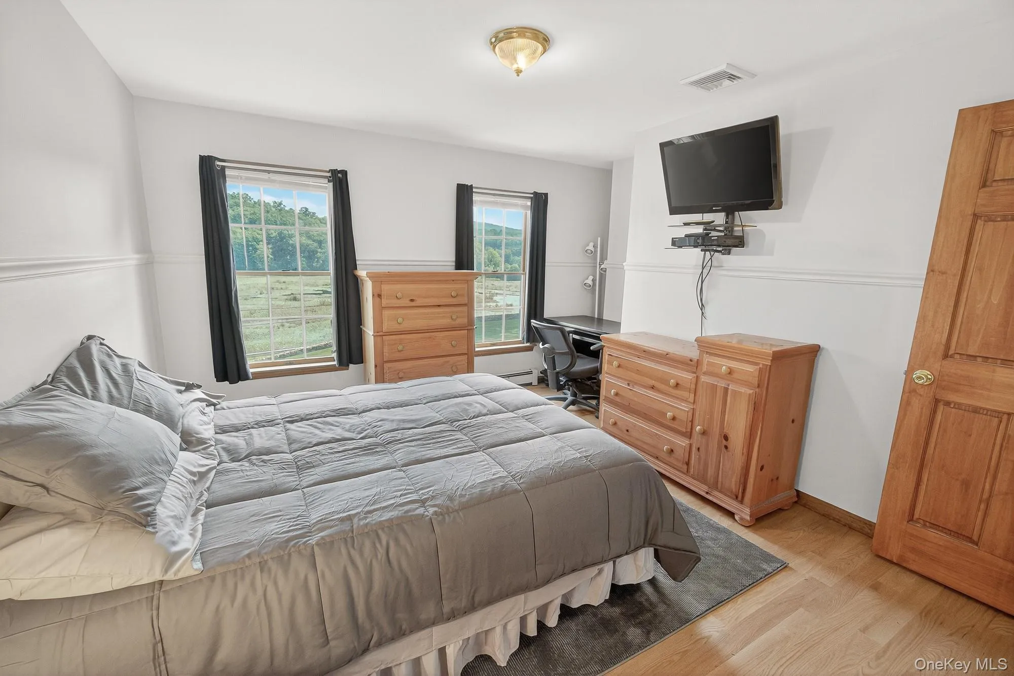 Bedroom featuring wood finished floors and an office area Bedroom featuring wood finished floors and an office area