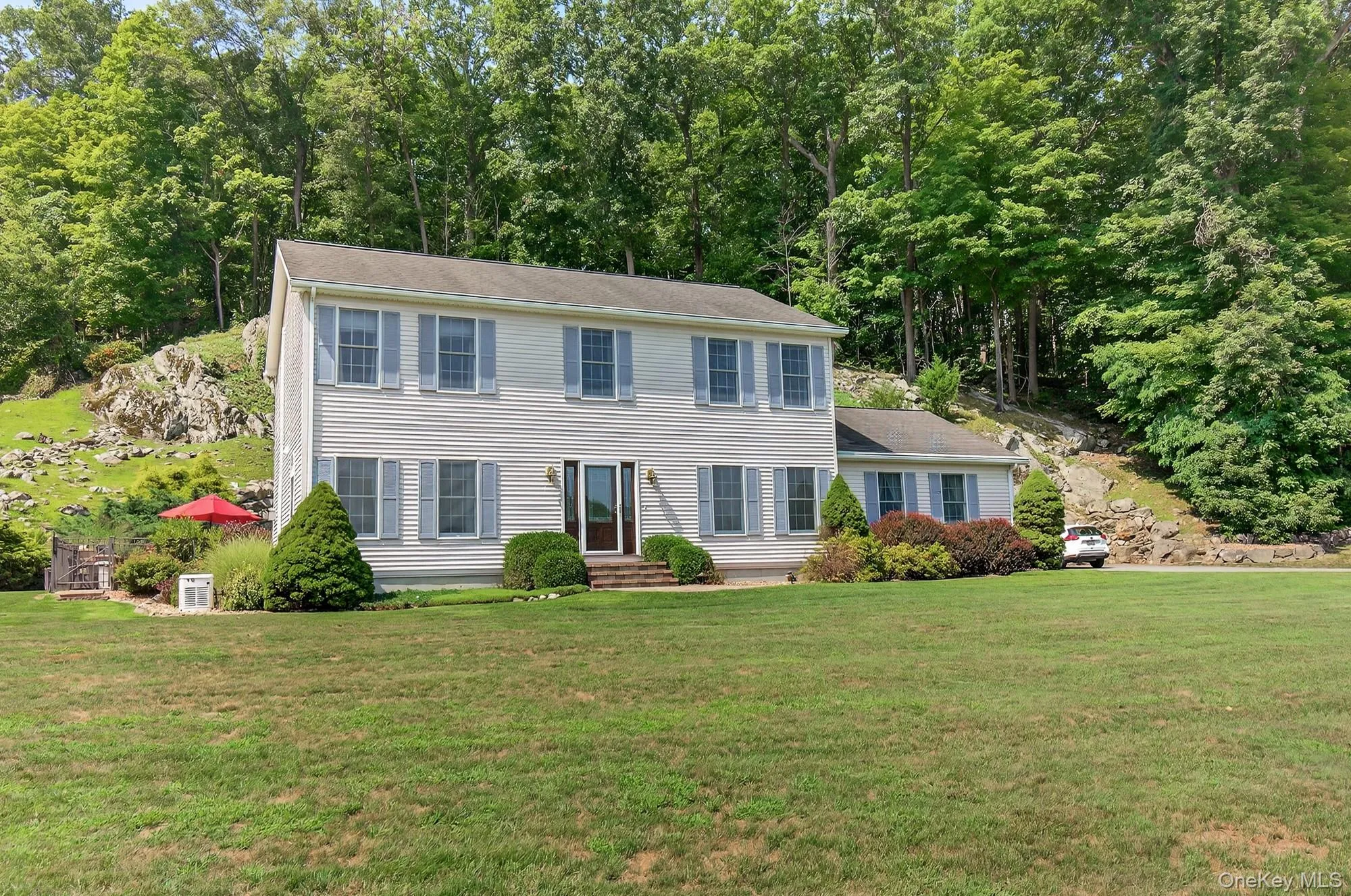 Colonial home featuring landscaping Colonial home featuring landscaping