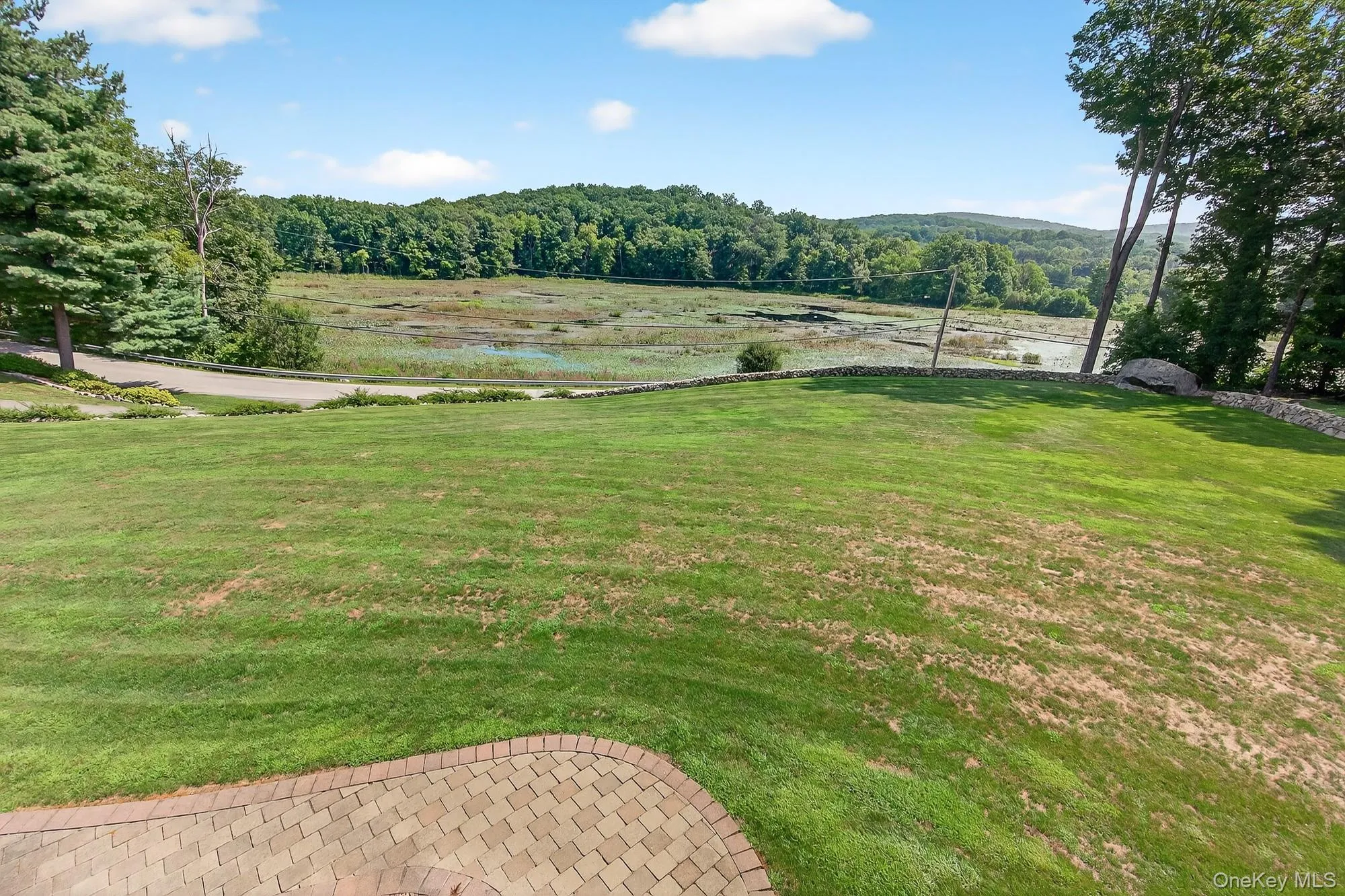 View of green lawn featuring a view of Barrett Pond View of green lawn featuring a view of Barrett Pond