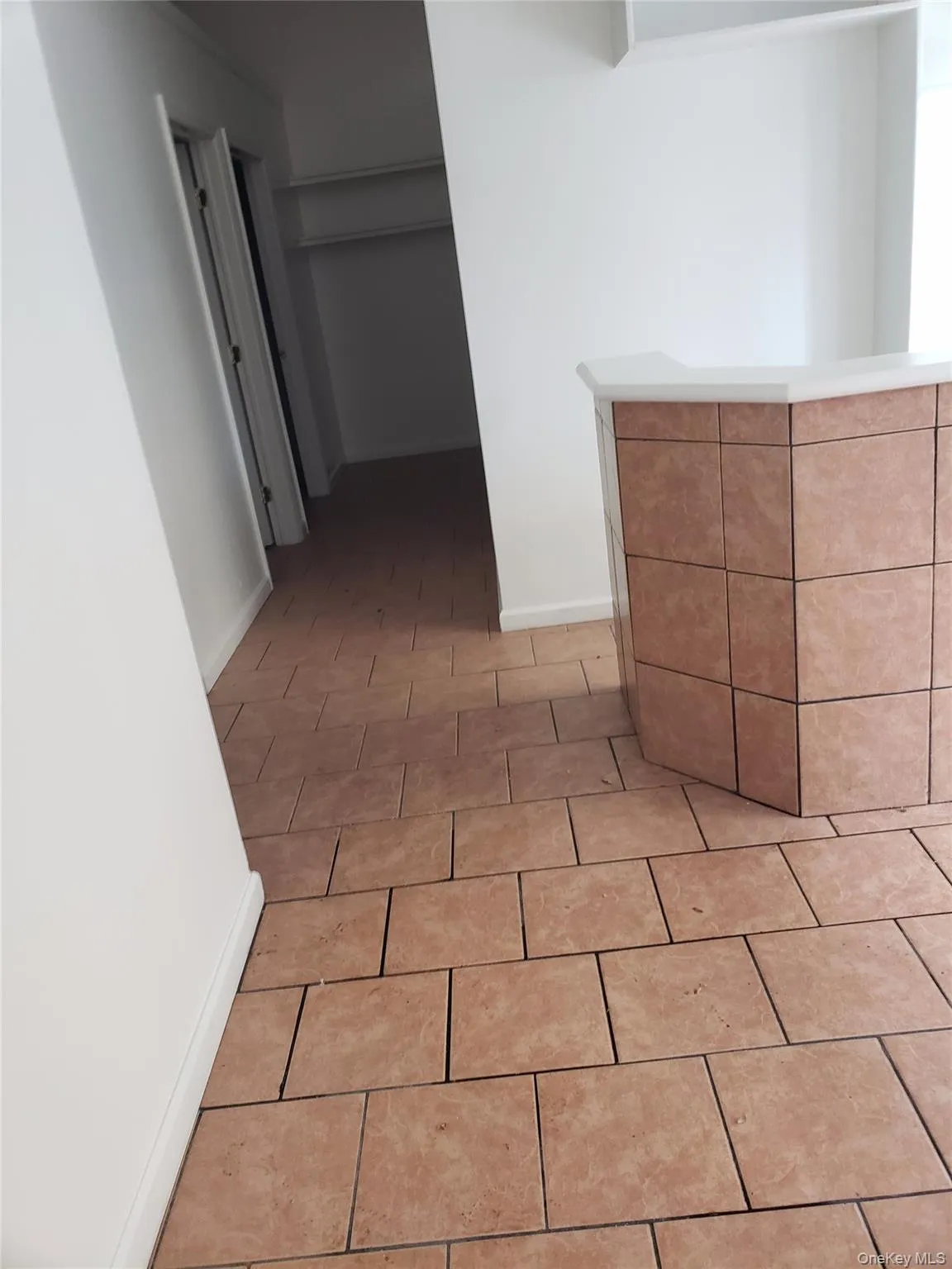 Hall with baseboards and light tile patterned floors Hall with baseboards and light tile patterned floors