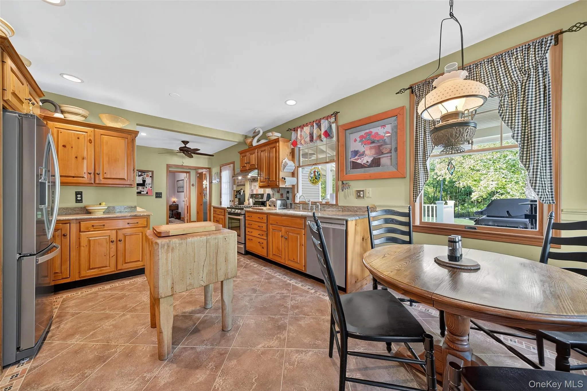 Kitchen featuring stainless steel appliances, hanging light fixtures, recessed lighting, a ceiling fan, and light tile patterned floors Kitchen featuring stainless steel appliances, hanging light fixtures, recessed lighting, a ceiling fan, and light tile patterned floors