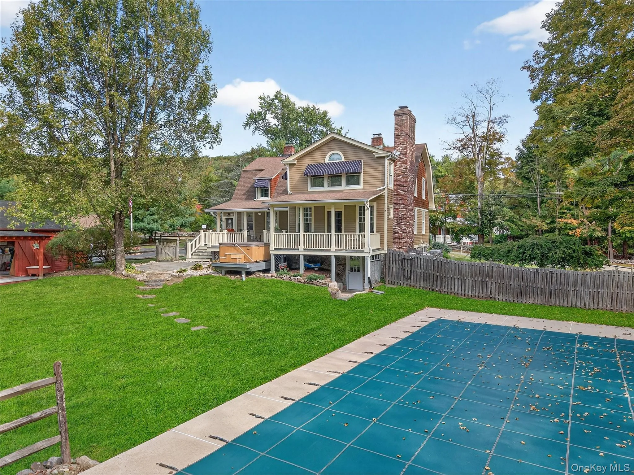 Rear view of house with a chimney, a patio area, and a porch Rear view of house with a chimney, a patio area, and a porch