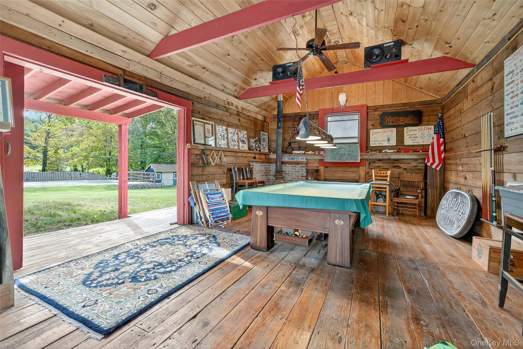 Recreation room featuring billiards table, wood-type flooring, wooden walls, wood ceiling, and a ceiling fan Recreation room featuring billiards table, wood-type flooring, wooden walls, wood ceiling, and a ceiling fan