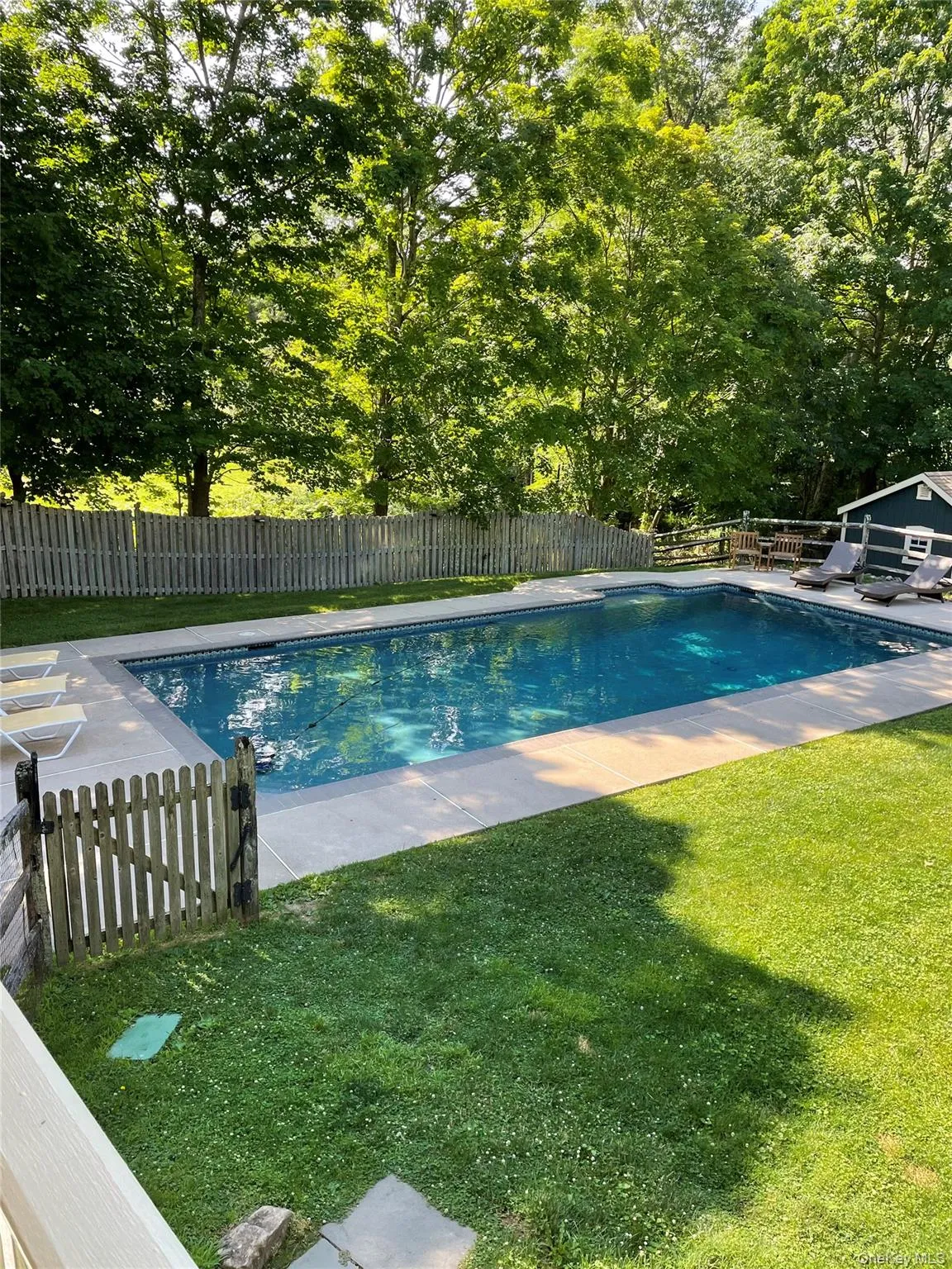 View of open swimming pool featuring a fenced backyard and a patio area View of open swimming pool featuring a fenced backyard and a patio area