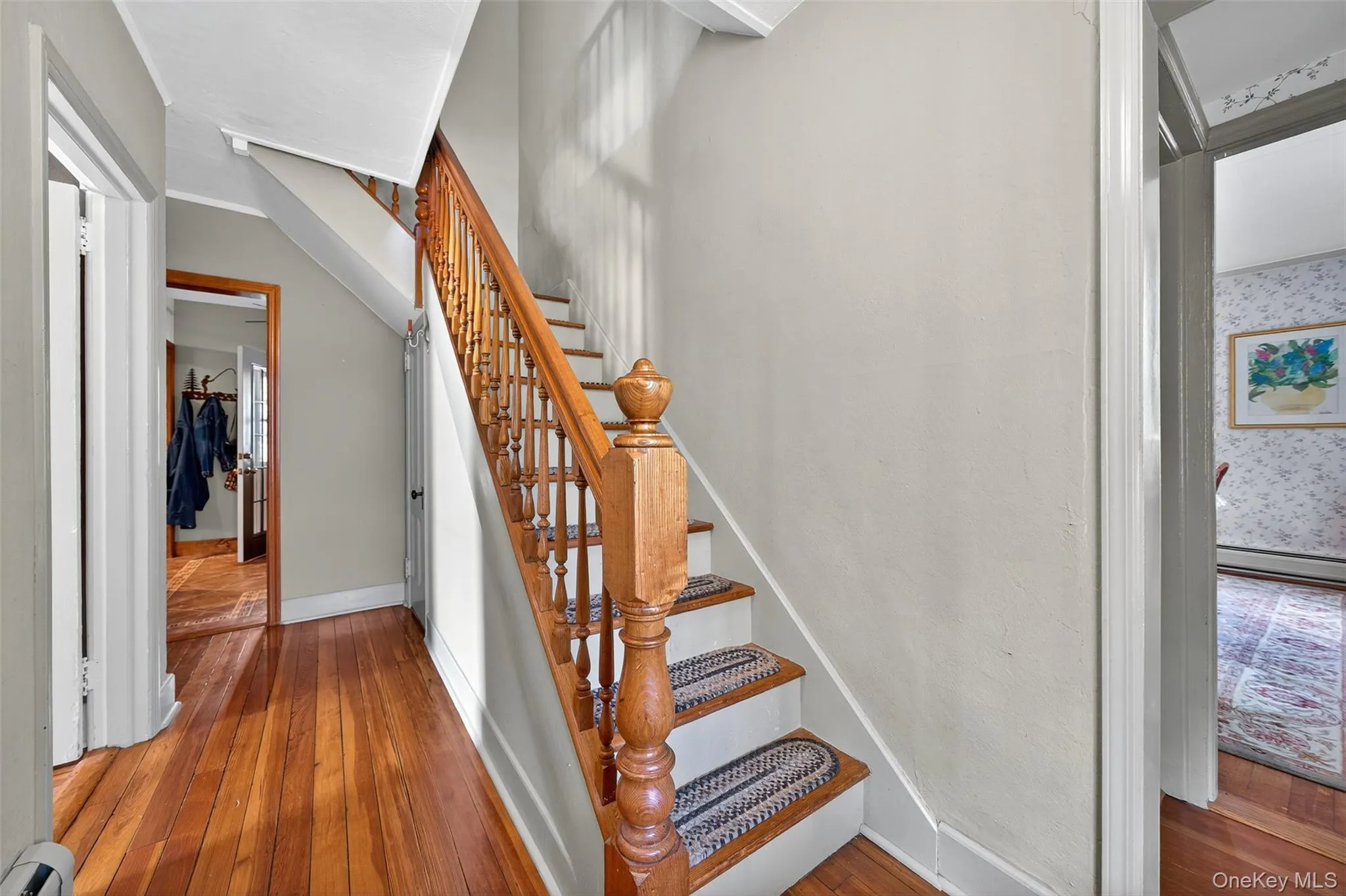 Stairs with hardwood / wood-style flooring and a baseboard heating unit Stairs with hardwood / wood-style flooring and a baseboard heating unit