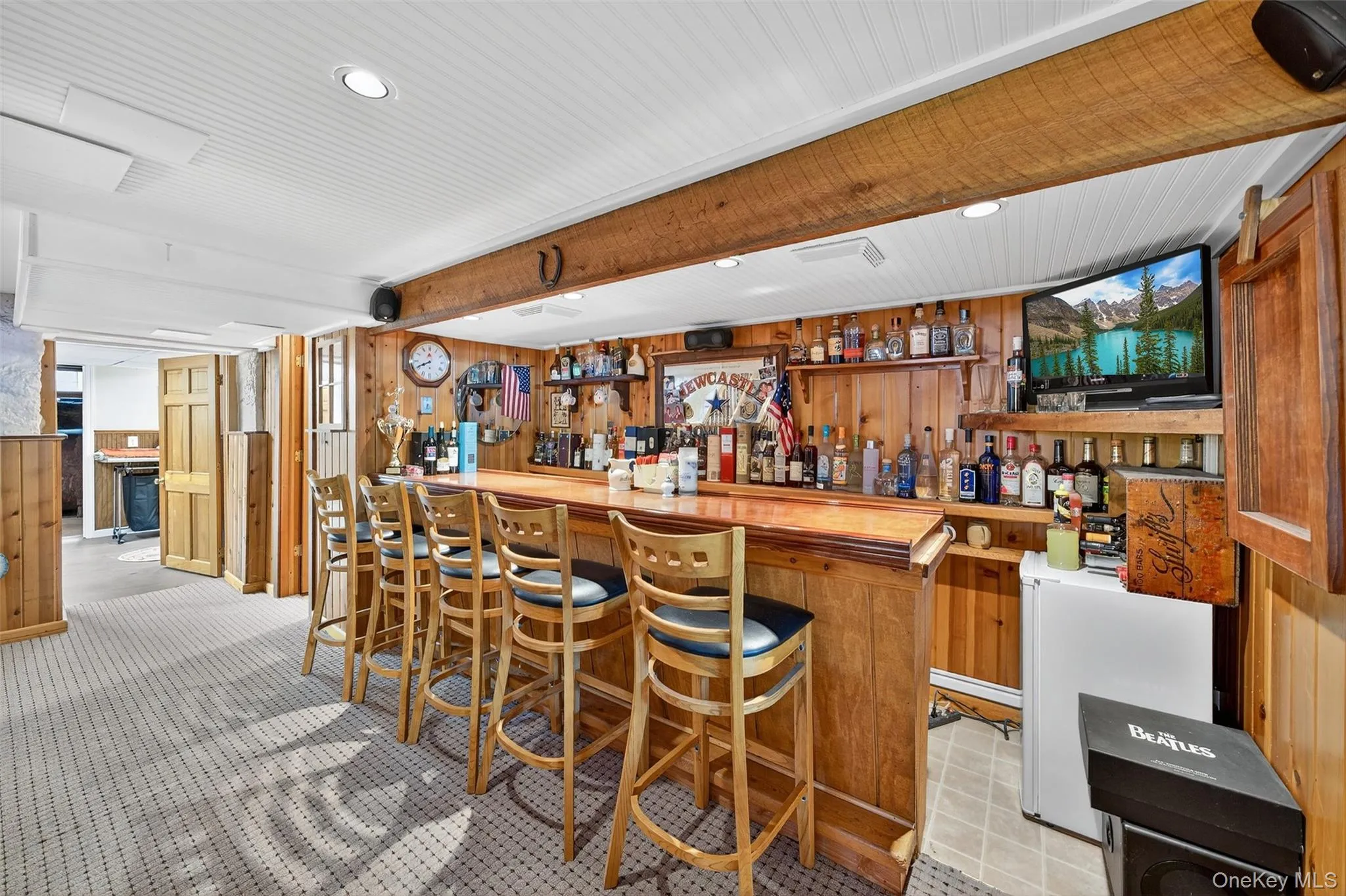 Indoor wet bar featuring wood walls, butcher block counters, recessed lighting, brown cabinetry, and open shelves Indoor wet bar featuring wood walls, butcher block counters, recessed lighting, brown cabinetry, and open shelves