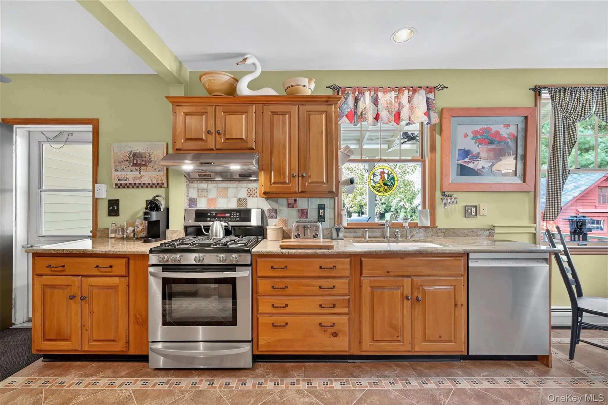 Kitchen with stainless steel appliances, backsplash, under cabinet range hood, light stone countertops, and recessed lighting Kitchen with stainless steel appliances, backsplash, under cabinet range hood, light stone countertops, and recessed lighting