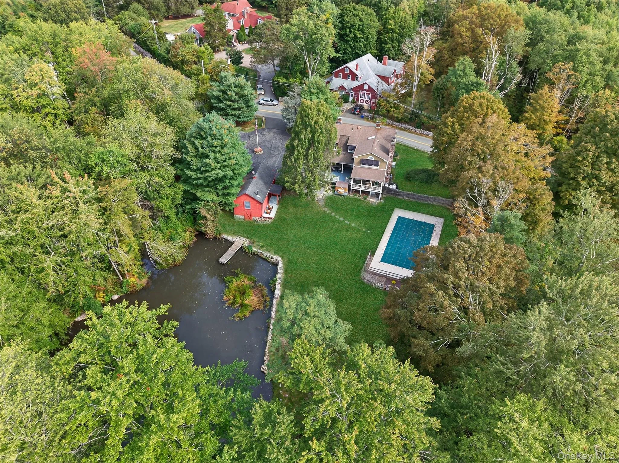 Aerial view of property's location with a pool area and beautiful private pond Aerial view of property's location with a pool area and beautiful private pond