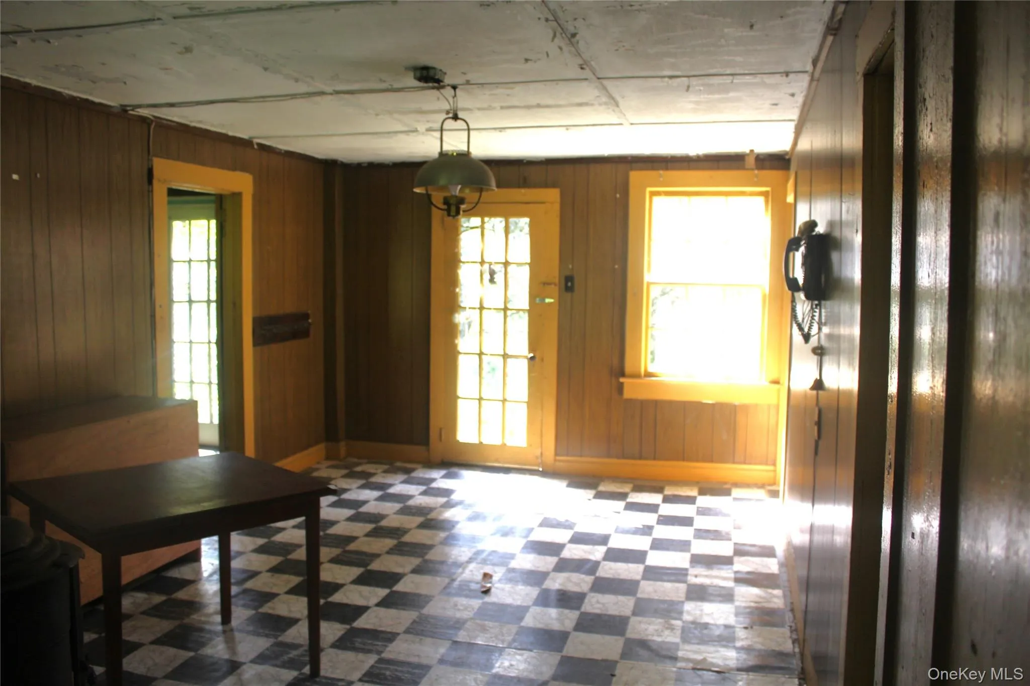 Entryway featuring tile patterned floors, plenty of natural light, and wood walls Entryway featuring tile patterned floors, plenty of natural light, and wood walls